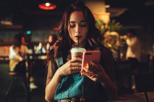 カフェでスマホをいじる女性