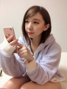 部屋着でスマホを操作する女性