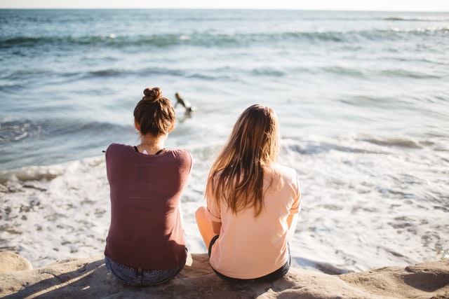 海辺に座る女性2人