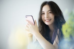 スマホを持つ笑顔の美人女性