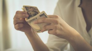 1万円札を数える女性の手