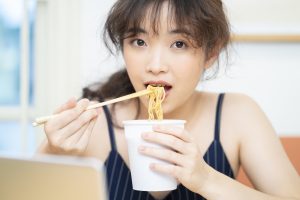 カップラーメンを食べる女性