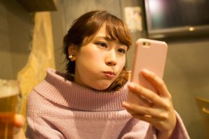 スマホを見る不機嫌な女性