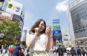 都会の真ん中でスマホを見る女性