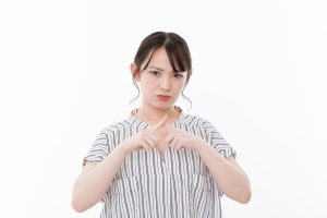 バツのジェスチャーをする女性