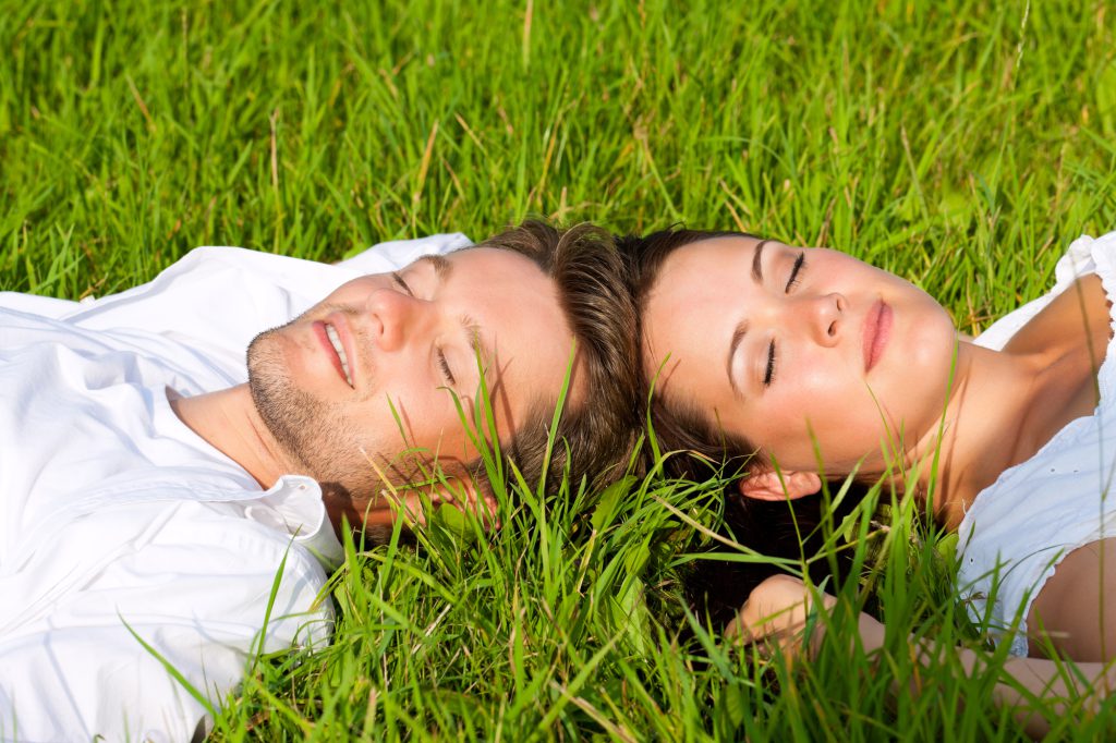 芝生に寝転がるカップル
