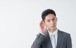噂話を聞くサラリーマン